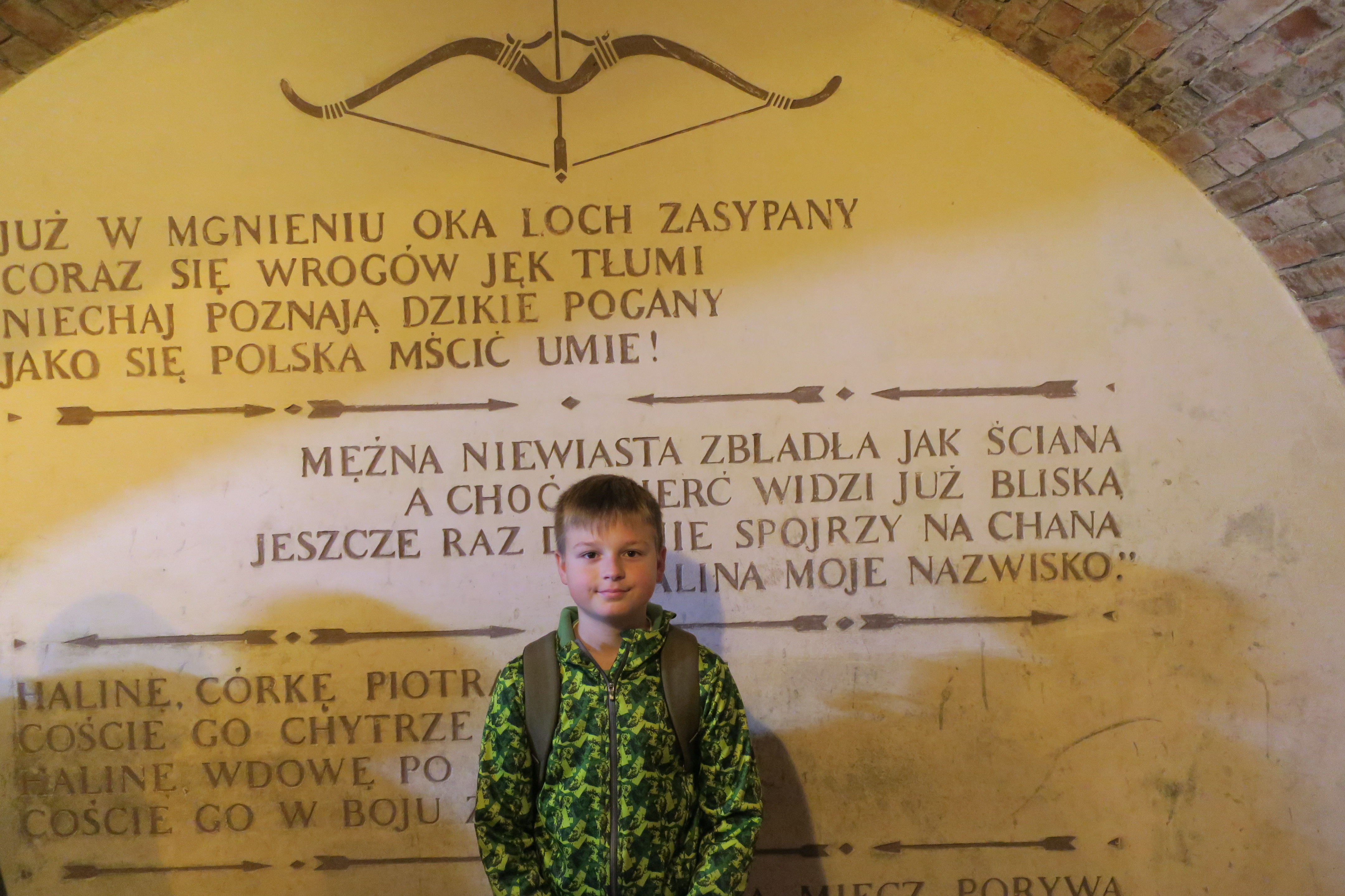 Uczeń na tle ściennego napisu 