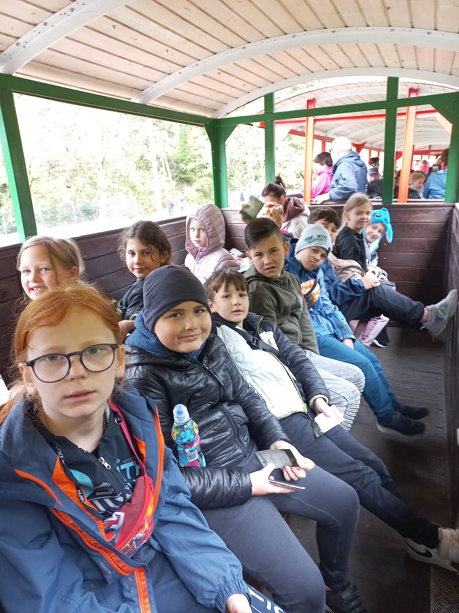 Grupa dzieci w wagoniku kolejki wąskotorowej