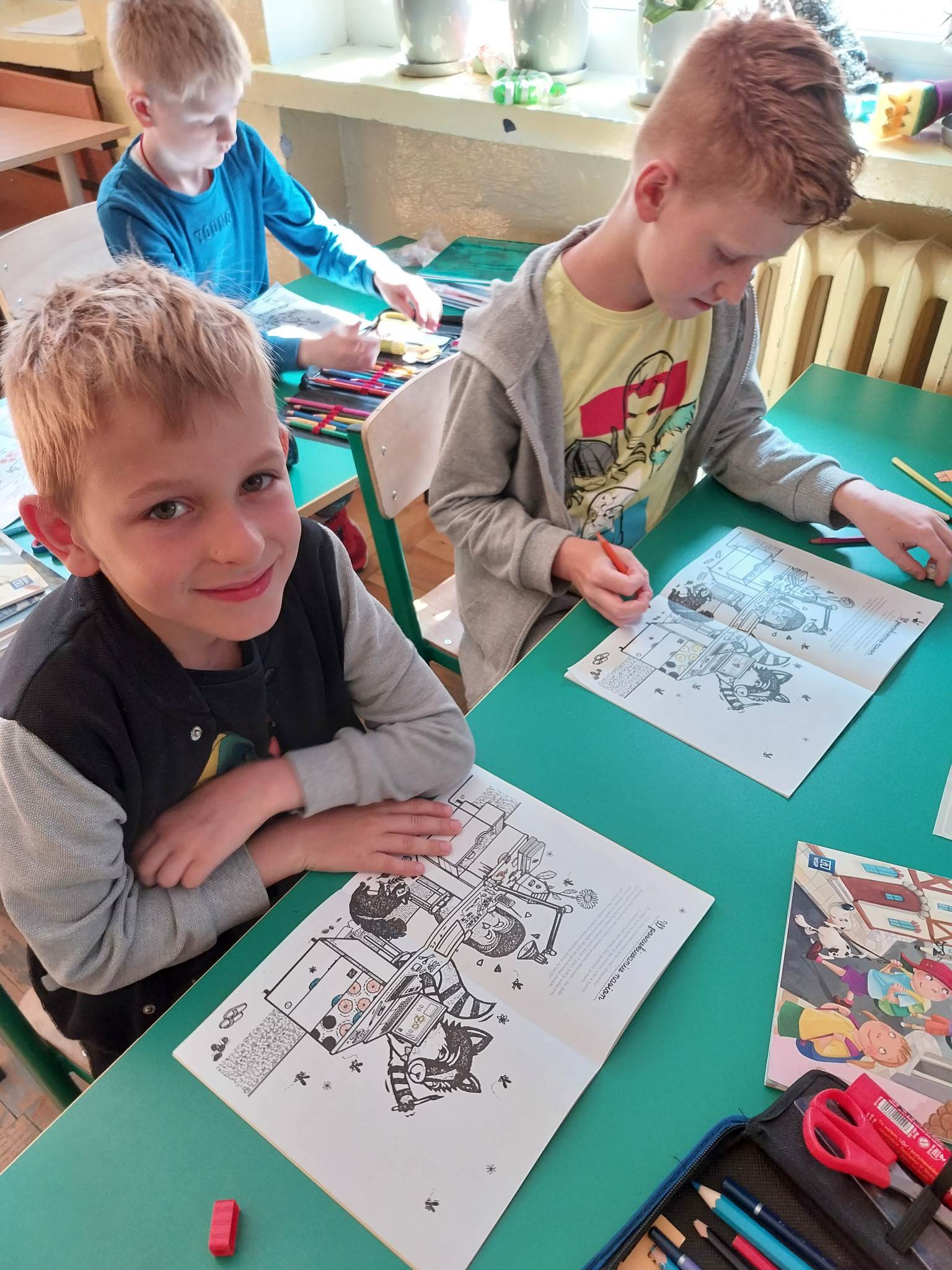 Dwaj chłopcy w ławce rozwiązują zadania w zeszytach