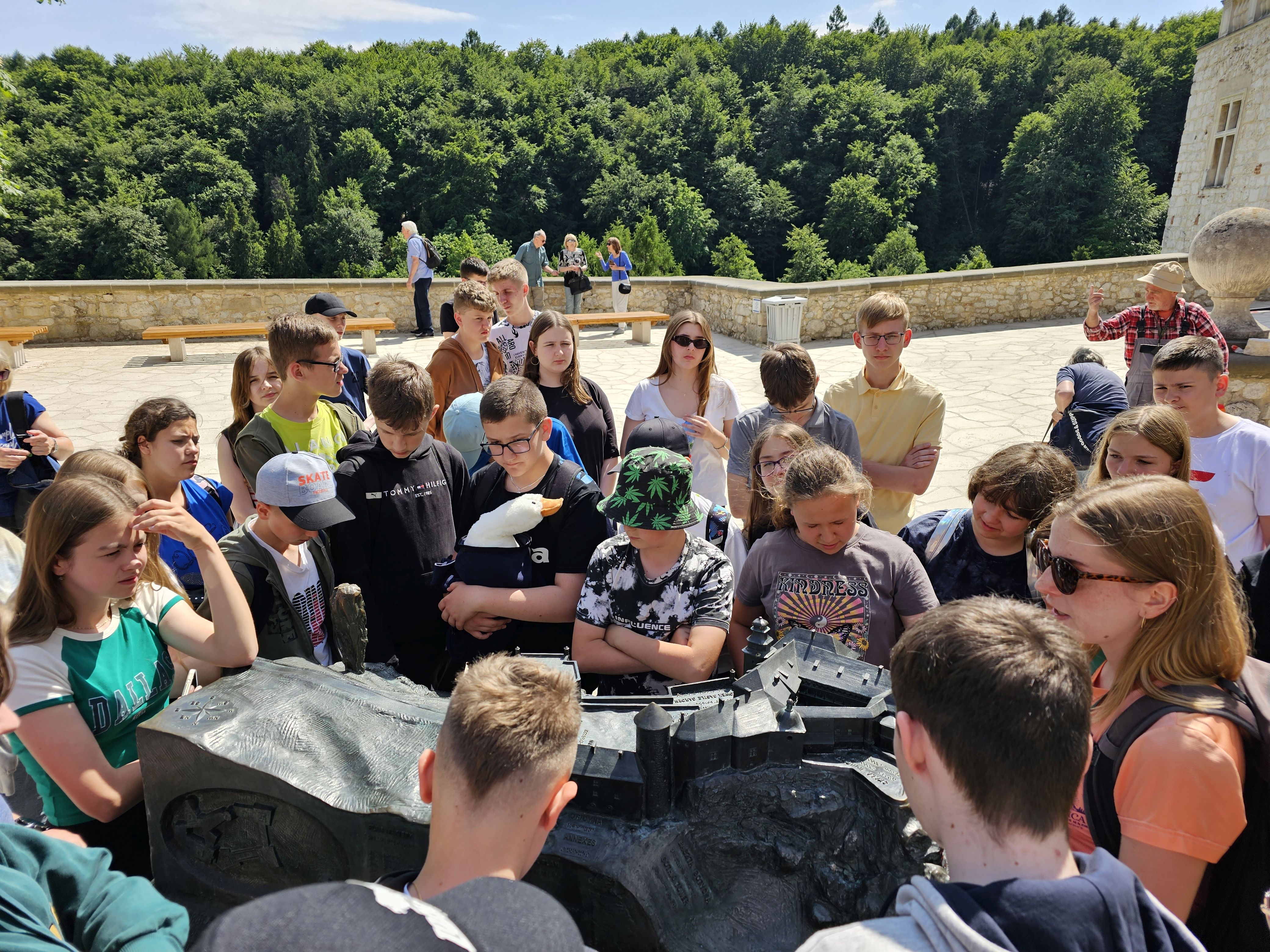 Uczniowie oglądają na dziedzińcu zamku makietę zamku na Pieskowej Skale