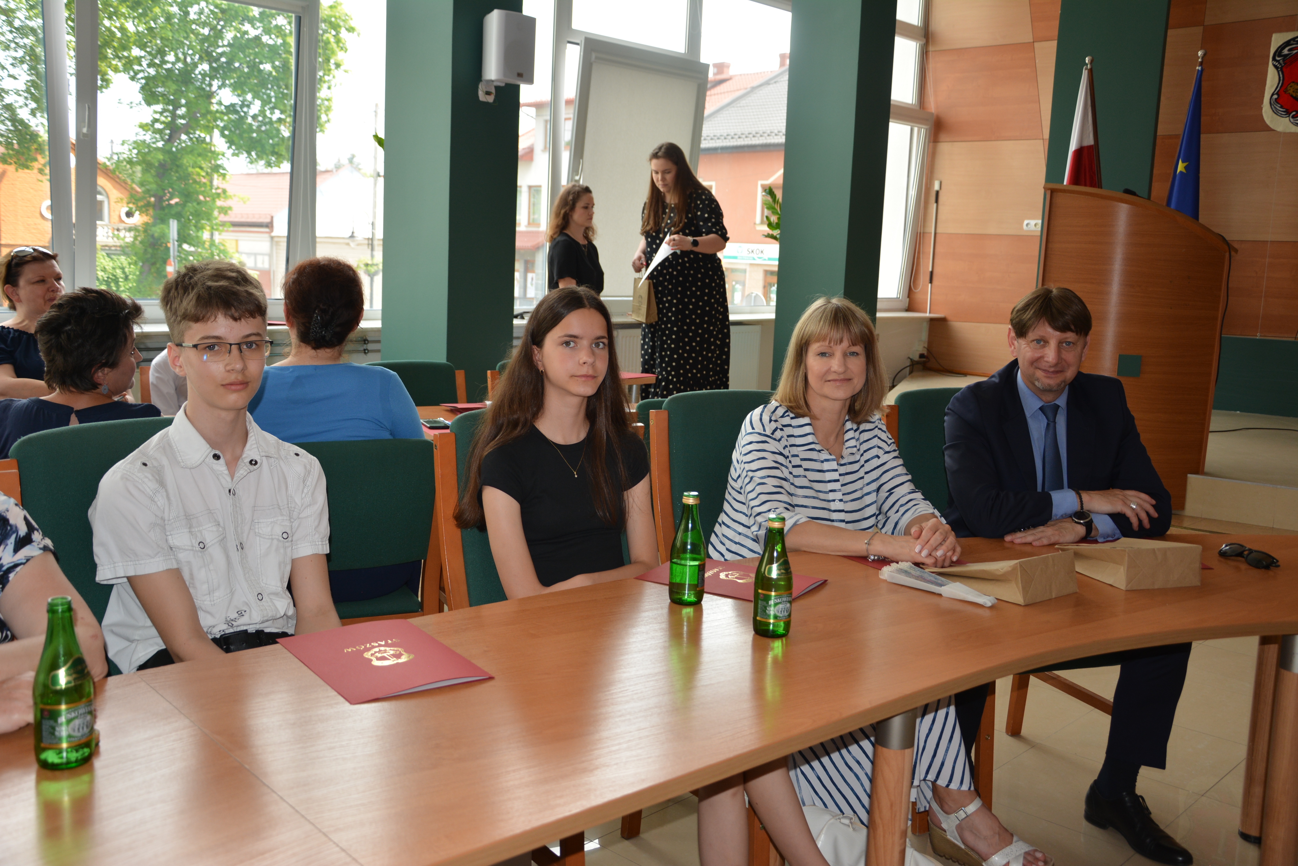 Dwoje uczniów, nauczycielka, dyrektor w sali konferencyjnej urzędu miasta