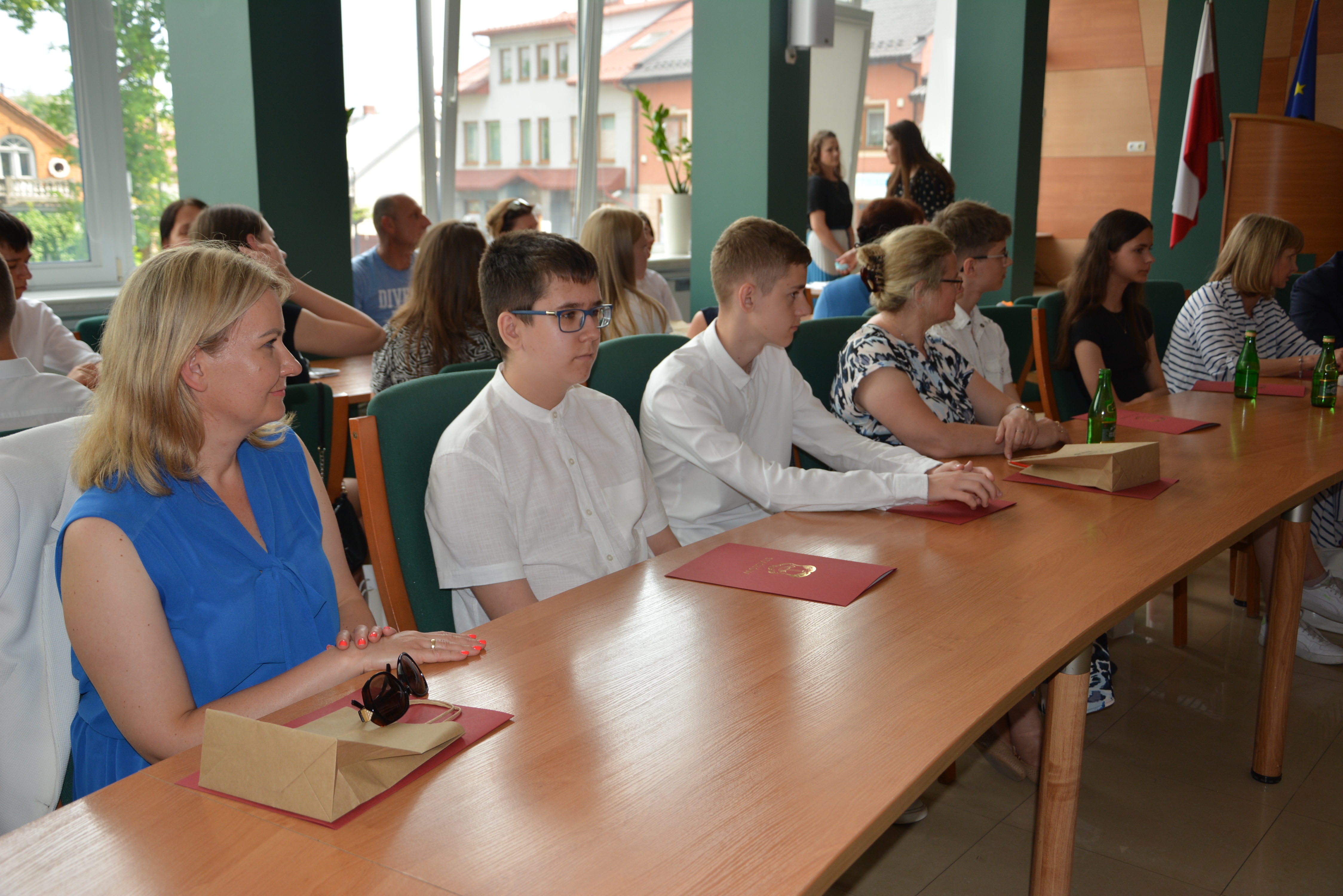 Czworo uczniów, nauczycielki w sali konferencyjnej urzędu miasta