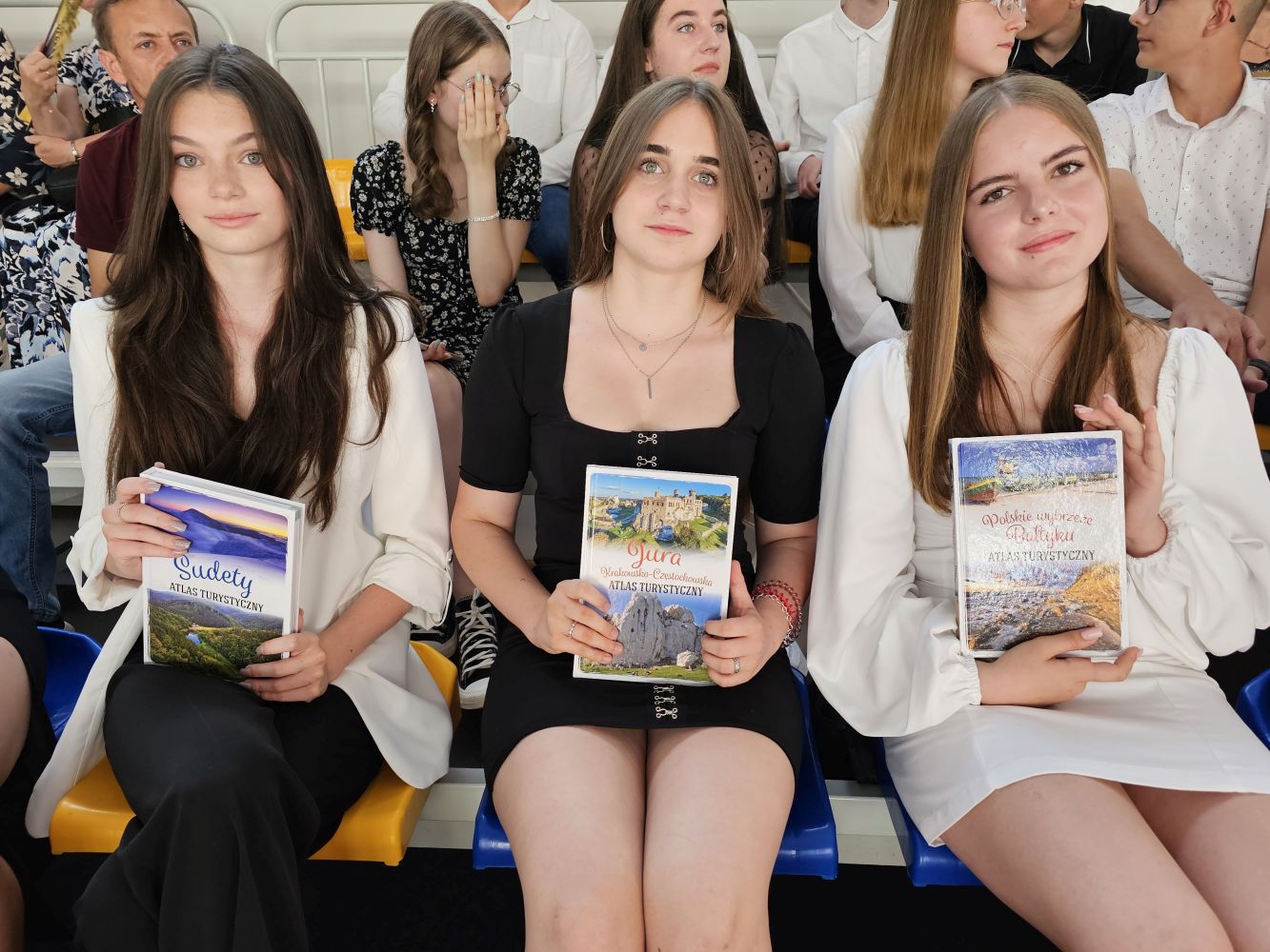 Trzy uczennice z nagrodami na widowni